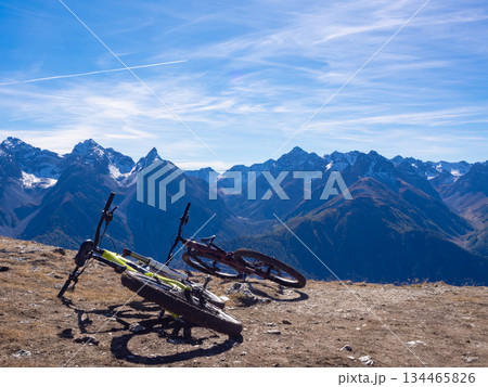 Scuol, Switzerland - October 11th 2025: Two bikes in front of the impressive view from motta naluns biking resort 134465826