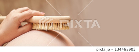 Pregnant female body brushing belly with natural bristle brush for skin care Pregnant female body brushing belly with natural bristle brush for skin care 134465903