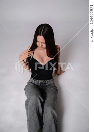 Woman fashion studio portrait of young model in casual black top and jeans Woman fashion studio portrait of young model in casual black top and jeans 134465971