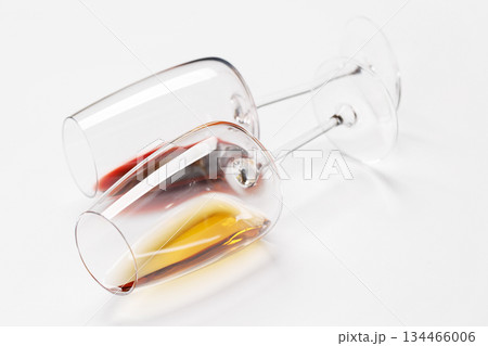 Wine glasses with red and white wine lying on white background Wine glasses with red and white wine lying on white background 134466006