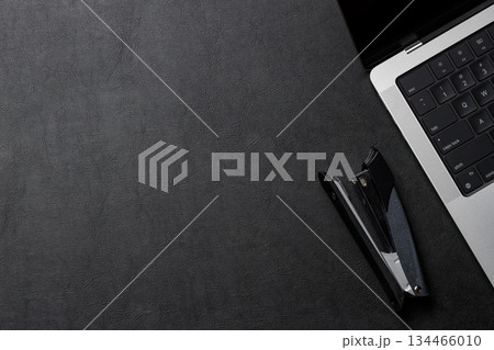Office supplies and laptop on black leather workspace, top view with copy space 134466010