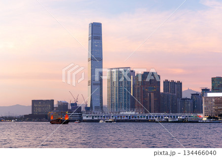 Hong Kong city skyline at sunset with glowing sky and skyscrapers 134466040