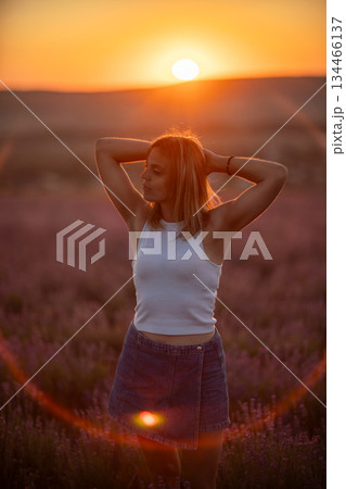 Woman lavender sunset standing peaceful field during warm summer golden hour light 134466137