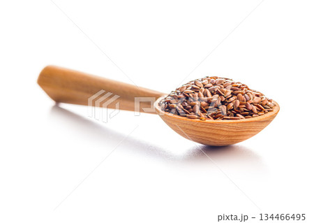 Linseed or flaxseed. Healthy flax seed on wooden spoon isolated on white background. 134466495