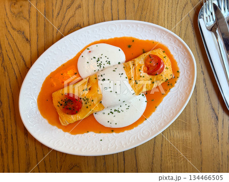 Omelette with sauce and cherry tomatoes. Freshness, comfort and culinary creativity in presentation. Omelette with sauce and cherry tomatoes. Freshness, comfort and culinary creativity in presentation. 134466505
