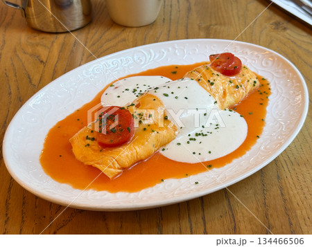 Omelette with sauce and cherry tomatoes. Freshness, comfort and culinary creativity in presentation. Omelette with sauce and cherry tomatoes. Freshness, comfort and culinary creativity in presentation. 134466506