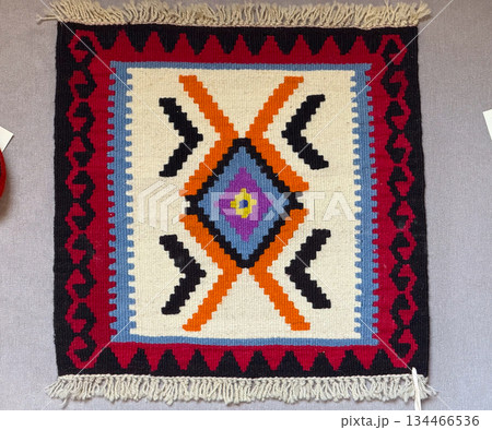 Traditional woven rug with geometric pattern. Connection between heritage, craftsmanship and cultural symbolism. Traditional woven rug with geometric pattern. Connection between heritage, craftsmanship and cultural symbolism. 134466536