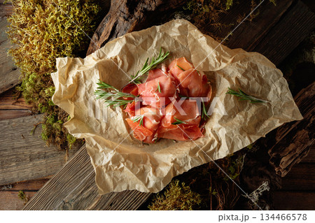 Prosciutto slices with rosemary wrapped in paper. Prosciutto slices with rosemary wrapped in paper. 134466578