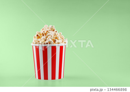 Classic red striped popcorn cardboard cup on Green background 134466898
