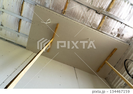 Room under construction with silver aluminum insulation foil and drywall on walls and ceiling. Room under construction with silver aluminum insulation foil and drywall on walls and ceiling. 134467159