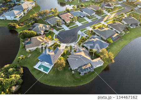 American dream homes at evening on rural cul-de-sac street in US suburbs. View from above of waterfront residential houses in living area in North Port, Florida 134467162