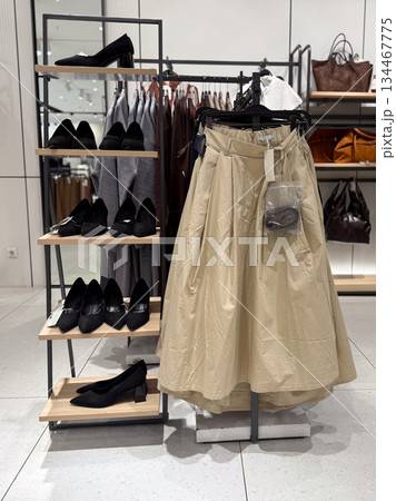Shoes, skirts and leather bags are displayed together in a section of a fashion store. Retail commerce, consumer choice, accessories, textile and apparel trade in modern shopping culture. Shoes, skirts and leather bags are displayed together in a section of a fashion store. Retail commerce, consumer choice, accessories, textile and apparel trade in modern shopping culture. 134467775
