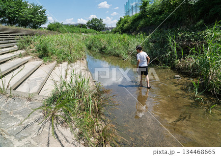 楽しい夏休みに日差しを浴びて川遊びをしている少年 134468665