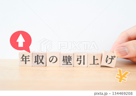 年収の壁引き上げを示すブロックと上向き矢印の写真。 134469208