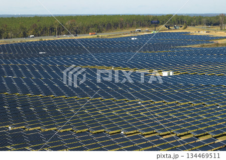 Aerial view of big sustainable electric power plant with many rows of solar photovoltaic panels for producing clean electrical energy. Renewable electricity with zero emission concept Aerial view of big sustainable electric power plant with many rows of solar photovoltaic panels for producing clean electrical energy. Renewable electricity with zero emission concept 134469511