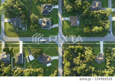 Aerial view of american yellow school bus picking up children at sidewalk bus stop for their lessongs in early morning. Public transportation in the USA Aerial view of american yellow school bus picking up children at sidewalk bus stop for their lessongs in early morning. Public transportation in the USA 134469528