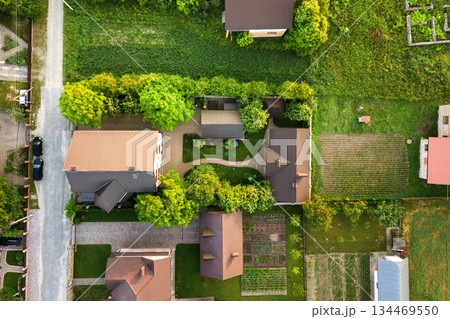 Aerial landscape of small town or village with rows of residential homes and green trees. 134469550