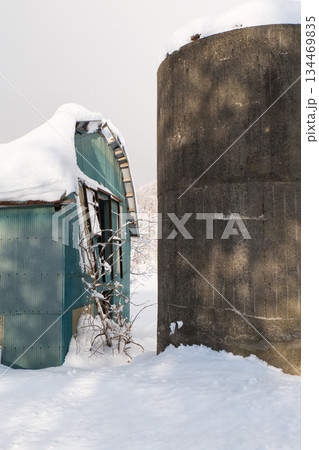 雪国の静かで穏やかな朝屋根に雪が積もった納屋とサイロ 雪国の静かで穏やかな朝屋根に雪が積もった納屋とサイロ 134469835