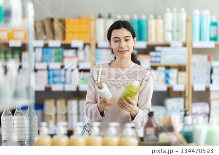 woman chooses a shampoo in a pharmacy 134470593