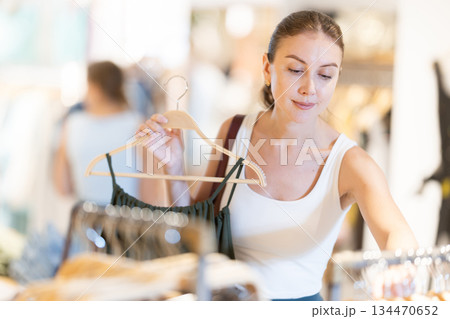Young woman choosing dress in clothing store 134470652