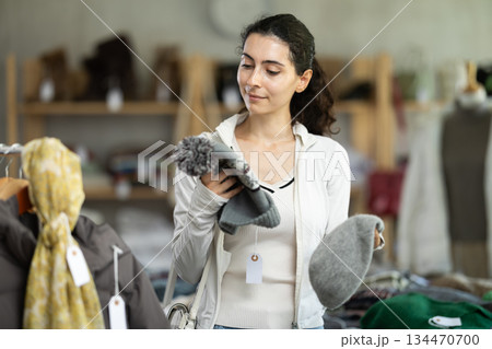 Armenian woman near showcase examine goods, hat. 134470700