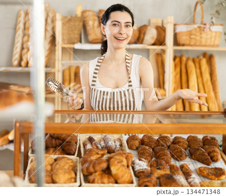 Young woman seller at showcase with pastries 134471348
