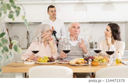 Elderly parents with daughter and son-in-law enjoying dinner Elderly parents with daughter and son-in-law enjoying dinner 134471378