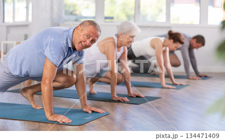 Elderly man doing pilates in group 134471409