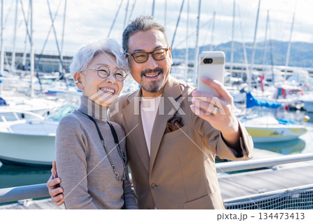 港で自撮りをするシニア夫婦　撮影協力:道の駅伊東マリンタウン 134473413