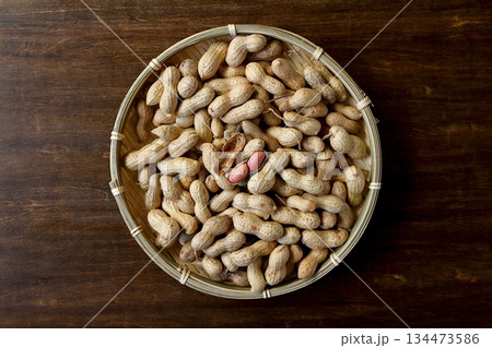 真上から見たテーブル背景の竹ざるに盛った沢山の殻付き落花生 134473586