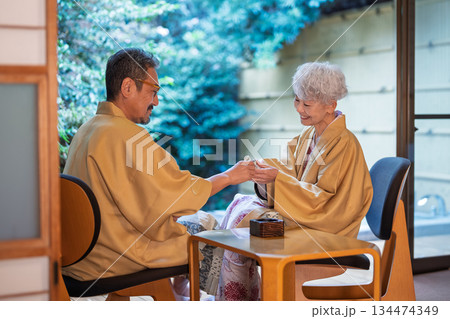 旅館の縁側で日本酒を飲むシニア夫婦　撮影協力:伊東緑涌 134474349