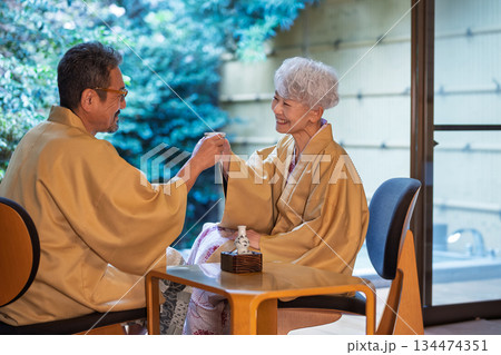 旅館の縁側で乾杯をするシニア夫婦　撮影協力:伊東緑涌 134474351