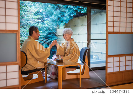 旅館の縁側で乾杯をするシニア夫婦　撮影協力:伊東緑涌 134474352