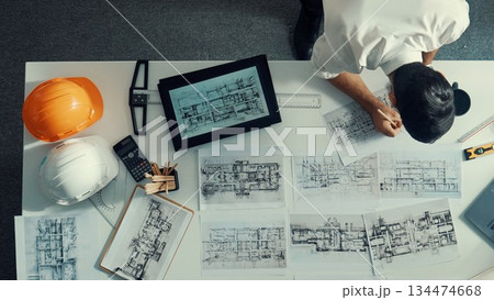 Top view of engineer looking at tablet while looking at laptop. Alimentation. 134474668