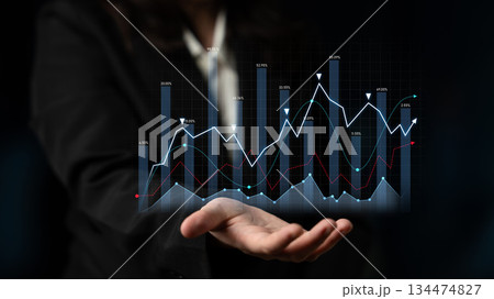 Business professional demonstrates growth and analytics through virtual chart representation on hand, showcasing key financial metrics and trends. Scalp 134474827