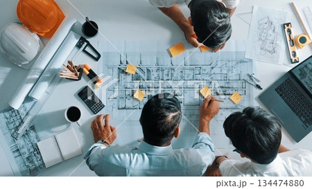 Top view of designer writing at sticky note while planning design. Alimentation. 134474880