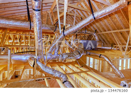 Construction site ductwork installation in new building under construction with wood framing 134476160