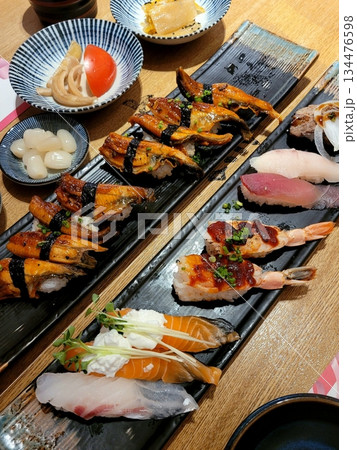 An assortment of fresh sushi, artfully arranged with a variety of toppings and vibrant colors. This traditional Japanese dish combines vinegared rice, seafood, and vegetables for an experience. 134476598