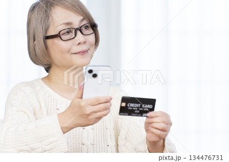 スマホ決済をするシニア女性 134476731
