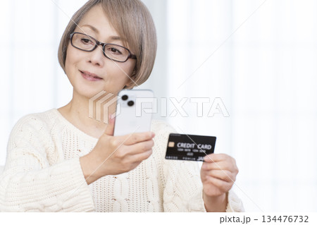 スマホ決済をするシニア女性 134476732