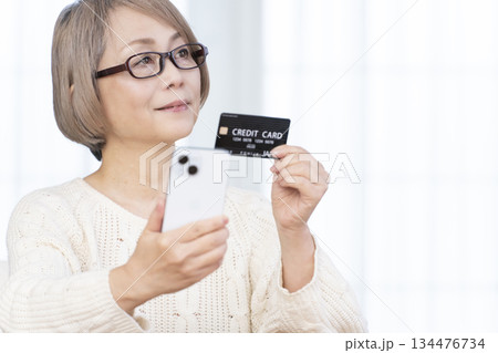 スマホ決済をするシニア女性 134476734