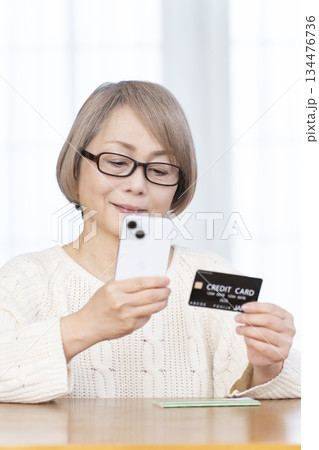 スマホ決済をするシニア女性 134476736