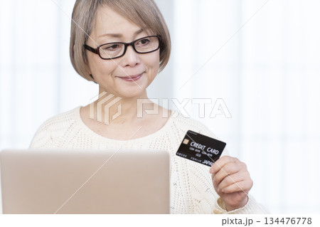パソコンでネットショッピングを楽しむシニア女性 134476778