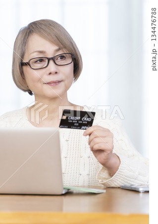 パソコンでネットショッピングを楽しむシニア女性 134476788