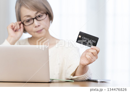 パソコンでネットショッピングを楽しむシニア女性アウトフォーカス パソコンでネットショッピングを楽しむシニア女性アウトフォーカス 134476826