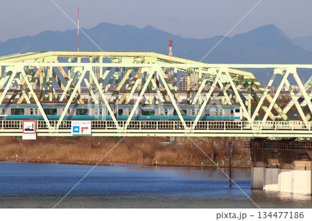 冬の荒川橋梁を渡る京浜東北線E233系電車と秩父連山 134477186