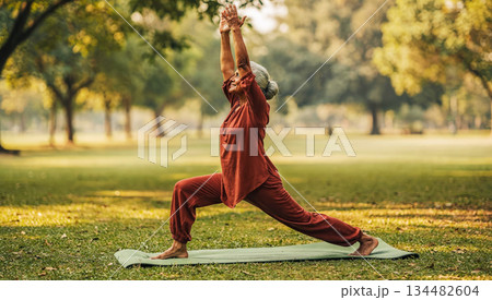 Daily exercise practice in the park. Poster of an elderly Indian woman performing yoga asanas in the morning in a park. Physical activity practice for older adults 134482604