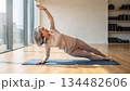 A beautiful elderly Japanese woman doing Pilates exercises in a gym. A practice of mindfulness and regular exercise for older adults 134482606