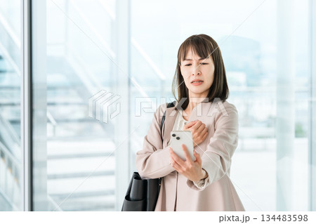 老眼,かすみ目,眼精疲労でスマホの画面がよく見えないアジア人ビジネスウーマン 134483598