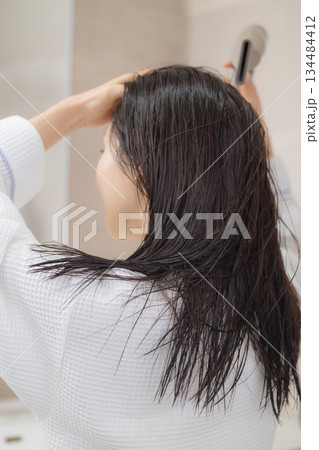 ドライヤーで髪の毛を乾かす若い女性 134484412